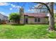 Spacious backyard with lush green grass, mature trees, and a stone chimney feature on the home's exterior at 1829 Catalano Dr, Indianapolis, IN 46214