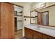 Bathroom with wood vanity, well-lit mirror and view to closet at 1829 Catalano Dr, Indianapolis, IN 46214