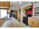 Kitchen with wood cabinets, black appliances, and a bright red accent wall at 1829 Catalano Dr, Indianapolis, IN 46214