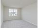 A simple bedroom features neutral carpet, a window, and white walls at 18944 Seaforth Way, Westfield, IN 46074