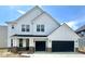 New construction home boasts a white exterior with a three-car garage and charming architectural details at 18944 Seaforth Way, Westfield, IN 46074