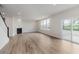 Open concept living room featuring a fireplace, sliding glass doors to the patio, and wood floors at 18944 Seaforth Way, Westfield, IN 46074