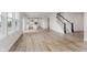 Open concept living room with a fireplace, and wood floors leading to the kitchen area at 18944 Seaforth Way, Westfield, IN 46074