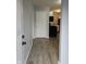 Inviting entryway with wood-look flooring that leads to a kitchen with black appliances at 1931 Brentwood Dr, Anderson, IN 46011
