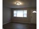 Open living room featuring new vinyl flooring, a large window and a white front door at 1931 Brentwood Dr, Anderson, IN 46011