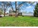 Large, well-maintained backyard featuring a mature tree, green lawn, and a view of the home's exterior at 2001 Winchester Dr, Indianapolis, IN 46227