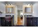 Well-lit bathroom with dual vanities, modern lighting fixtures, and a glimpse into the connecting bedroom at 2001 Winchester Dr, Indianapolis, IN 46227