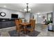 Open concept dining area featuring a large flat screen TV, dark cabinets, and a tile floor at 2001 Winchester Dr, Indianapolis, IN 46227