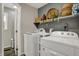Functional laundry room with modern washer and dryer units, complemented by shelving for organized storage at 2001 Winchester Dr, Indianapolis, IN 46227