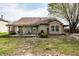 Backyard featuring a covered patio with seating, small grill, mature tree, and partial grass coverage at 2034 Milburn Dr, Brownsburg, IN 46112