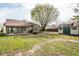 Charming backyard featuring a storage shed, mature trees, and partially covered patio with seating area at 2034 Milburn Dr, Brownsburg, IN 46112