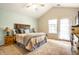 Primary bedroom with vaulted ceiling, ceiling fan, cozy decor, and access to a private balcony at 2034 Milburn Dr, Brownsburg, IN 46112