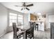Bright dining room with a ceiling fan, wood floors, a bar, and large windows for natural light at 2034 Milburn Dr, Brownsburg, IN 46112