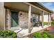 Inviting covered front porch with rocking chairs, decorative plants and stylish front door at 2034 Milburn Dr, Brownsburg, IN 46112
