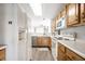 Traditional kitchen with oak cabinets, white appliances, light countertops, and plank flooring at 2034 Milburn Dr, Brownsburg, IN 46112