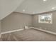Attic bedroom featuring a sloped ceiling, neutral walls, soft carpeting, and natural light from the window at 2103 Postmaster Ln, Greenfield, IN 46140