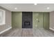 Spacious living room featuring hardwood floors, a black brick fireplace, and neutral green paint tones at 2103 Postmaster Ln, Greenfield, IN 46140