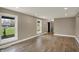 Bright living room featuring wood-look floors, fresh paint, and large windows offering plenty of natural light at 2103 Postmaster Ln, Greenfield, IN 46140