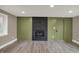 Bright living room featuring a brick fireplace, shiplap accent wall, and wood-look flooring at 2103 Postmaster Ln, Greenfield, IN 46140
