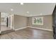 Open living room showcasing wood-look flooring, neutral walls, and a glimpse into the modern kitchen at 2103 Postmaster Ln, Greenfield, IN 46140