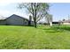 Expansive backyard featuring a lush lawn, mature tree, shed, and a glimpse of the home's exterior at 2206 Tansel Crossing Cir, Indianapolis, IN 46234