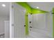 Bright bathroom with green wall, shower-tub, white door, and modern black fixtures at 2249 N Centennial St, Indianapolis, IN 46222