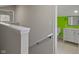 View of a staircase and a bright bathroom with a white vanity and a green accent wall at 2249 N Centennial St, Indianapolis, IN 46222