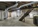 Unfinished basement with exposed ductwork, wooden stairs, laundry machines, and utility equipment at 2330 Harlan St, Indianapolis, IN 46203
