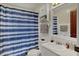 Bright bathroom featuring white fixtures, a vanity, and a shower with a stylish blue-striped curtain at 2330 Harlan St, Indianapolis, IN 46203