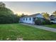 Charming single-story home with a well-maintained lawn and mature trees, offering a serene and inviting curb appeal at 2330 Harlan St, Indianapolis, IN 46203