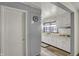 Well-lit kitchen area with white cabinetry, a stainless steel sink, and wood-look flooring at 2330 Harlan St, Indianapolis, IN 46203