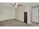 Brightly lit living room with carpeting, ceiling fan, and wall-mounted heater by the door at 2330 Harlan St, Indianapolis, IN 46203