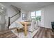 Dining area with wood table, white chairs, modern decor, vinyl wood-look flooring, and lots of natural light at 2741 Penn Ave, Plainfield, IN 46168