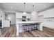 Bright, all-white kitchen featuring a center island with seating, stainless steel appliances, and wood-look floors at 2741 Penn Ave, Plainfield, IN 46168