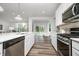 Gourmet kitchen with stainless steel appliances, white cabinets, quartz countertops, and wood-look vinyl plank flooring at 2741 Penn Ave, Plainfield, IN 46168