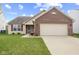 Charming single-story home featuring a brick facade, a well-manicured lawn, and an attached two-car garage at 3627 Miesha Dr, Indianapolis, IN 46217
