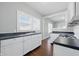 Well-lit kitchen features white cabinets, black countertops, and view into another room at 402 W 38Th St, Indianapolis, IN 46208