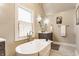 Luxurious bathroom showcasing a freestanding tub, vanity with a mirror, and abundant natural light at 4451 N Washington Blvd, Indianapolis, IN 46205
