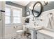 Well-lit bathroom with a pedestal sink, wainscoting, and stylish black and white tiled floor at 4451 N Washington Blvd, Indianapolis, IN 46205