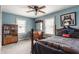 Cozy blue bedroom with a four-poster bed, ceiling fan, and natural light from the windows at 4451 N Washington Blvd, Indianapolis, IN 46205