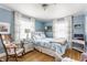 Charming blue bedroom featuring hardwood floors, natural light, and stylish décor at 4451 N Washington Blvd, Indianapolis, IN 46205