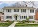 A welcoming two-story white home with classic design, landscaped garden, and inviting front entrance at 4451 N Washington Blvd, Indianapolis, IN 46205