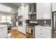 Modern kitchen features white cabinets, stainless steel appliances, stylish backsplash and hardwood floors at 4451 N Washington Blvd, Indianapolis, IN 46205