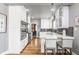Bright kitchen features white cabinets, stainless steel appliances, breakfast bar and hardwood floors at 4451 N Washington Blvd, Indianapolis, IN 46205