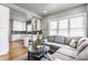 Open-concept living room with kitchen view, features hardwood floors and a comfortable sectional sofa at 4451 N Washington Blvd, Indianapolis, IN 46205