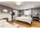 Serene main bedroom boasts hardwood floors, fireplace, sitting area, and natural light from a large window at 4451 N Washington Blvd, Indianapolis, IN 46205