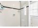 Clean white tiled shower with glass door, black accent stripe, and built-in shelving at 4451 N Washington Blvd, Indianapolis, IN 46205