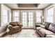 Cozy sunroom features a brick floor, multiple windows and a seating area with a sofa and a chair at 4451 N Washington Blvd, Indianapolis, IN 46205
