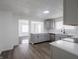 Contemporary kitchen with gray cabinets, white countertops, stainless steel appliances, and view to living room at 4897 Walker St, Greenwood, IN 46143