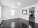 Bright living room featuring dark hardwood floors and an opening to a modern kitchen with gray cabinets at 4897 Walker St, Greenwood, IN 46143